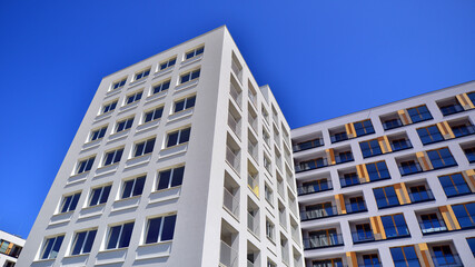 Fototapeta premium Contemporary residential building exterior in the daylight. Modern apartment buildings on a sunny day with a blue sky. Facade of a modern apartment building. 
