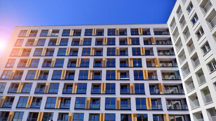 Contemporary residential building exterior in the daylight. Modern apartment buildings on a sunny day with a blue sky. Facade of a modern apartment building. 