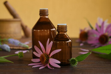 Fototapeta na wymiar Fragrant medical tincture of Echinacea purpurea in a glass bottles. Concrept of Herbal or homeopathy medicine. Flower essential oil. Herbal medicine. Side view.
