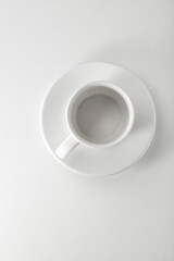 Taza con plato de porcelana blanca, vista cenital. White porcelain cup with saucer, overhead view.