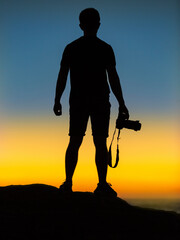 A Ukrainian photographer stands against the background of the sky in the colors of the Ukrainian flag.