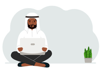 A man sits cross-legged in his hands holding a laptop. The concept of work, education, reading, watching videos.