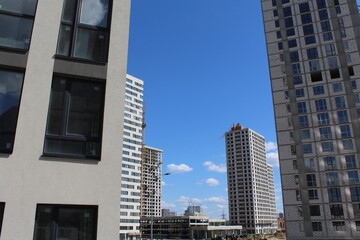 modern office building. facades of new high-rise buildings and construction site with cranes against blue clear sky background