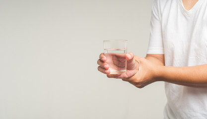 Parkinson's disease. Close-up of hands trying to hold a glass of water.