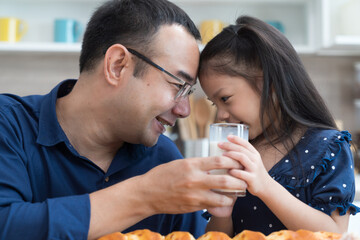 Happy Asian father and daughter in kitchen at home. Happy Asian family spending time together in kitchen at home