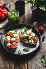 Bruschetta with mozzarella, tomatoes, basil and pesto in a plate. Bruschetta Caprese