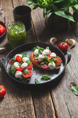 Bruschetta with mozzarella, tomatoes, basil and pesto in a plate. Bruschetta Caprese