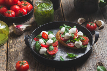Bruschetta with mozzarella, tomatoes, basil and pesto in a plate. Bruschetta Caprese