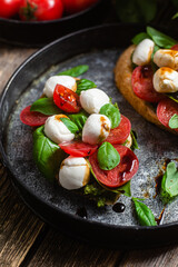 Bruschetta with mozzarella, tomatoes, basil and pesto in a plate. Bruschetta Caprese