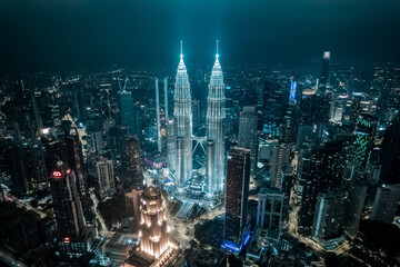 Tours Jumelles Petronas Tower et Ville de Kuala Lumpur la nuit dans une lumière bleutée et...