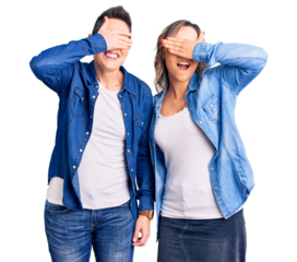 Couple of women wearing casual clothes smiling and laughing with hand on face covering eyes for surprise. blind concept.