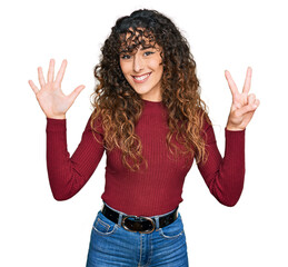 Young hispanic girl wearing casual clothes showing and pointing up with fingers number seven while smiling confident and happy.