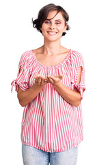 Beautiful young woman with short hair wearing casual summer clothes smiling with hands palms together receiving or giving gesture. hold and protection