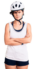 Beautiful young woman with short hair wearing bike helmet skeptic and nervous, disapproving expression on face with crossed arms. negative person.