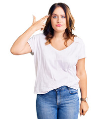 Young beautiful caucasian woman wearing casual white tshirt shooting and killing oneself pointing hand and fingers to head like gun, suicide gesture.