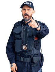 Young handsome man wearing police uniform pointing displeased and frustrated to the camera, angry and furious with you
