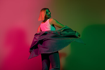 Photo of cute carefree girl dressed jeans shirt dancing having fun isolated pink green light color background