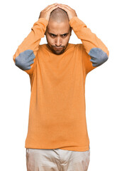 Fototapeta premium Hispanic adult man wearing casual winter sweater suffering from headache desperate and stressed because pain and migraine. hands on head.