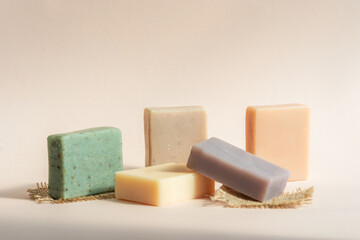 Pattern natural handmade soap of different sizes and colors. Brown background shadows of flowers...