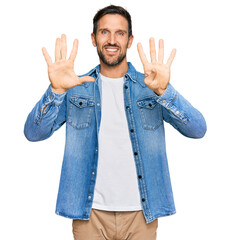 Young handsome man wearing casual denim jacket showing and pointing up with fingers number nine...