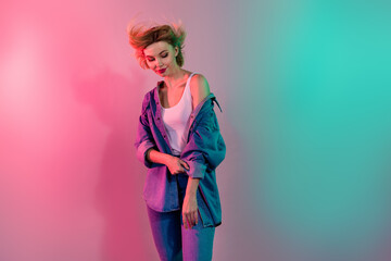 Photo of pretty shiny girl dressed jeans shirt smiling wind blowing isolated turquoise pink light color background