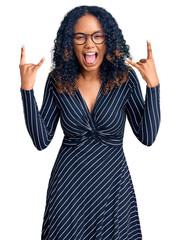 Young african american woman wearing casual clothes and glasses shouting with crazy expression...