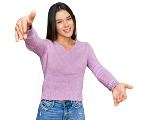 Young hispanic girl wearing casual clothes looking at the camera smiling with open arms for hug. cheerful expression embracing happiness.