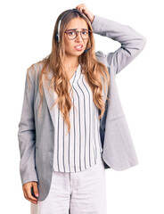 Young beautiful blonde woman wearing call center agent headset confuse and wonder about question....