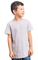 Cute blond kid wearing casual clothes looking away to side with smile on face, natural expression. laughing confident.