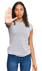 Young african american girl wearing casual clothes doing stop sing with palm of the hand. warning expression with negative and serious gesture on the face.