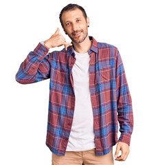 Young handsome man wearing casual clothes smiling doing phone gesture with hand and fingers like talking on the telephone. communicating concepts.