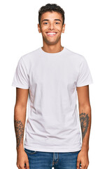 Obraz premium Young handsome african american man wearing casual white tshirt with a happy and cool smile on face. lucky person.