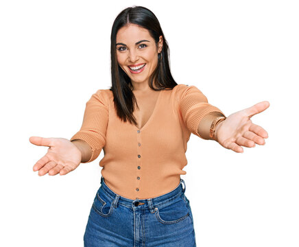 Young hispanic woman wearing casual clothes smiling cheerful offering hands giving assistance and acceptance.