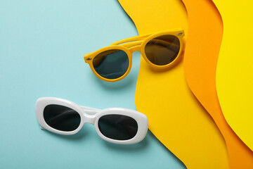 The concept of glasses on the beach, on a colored paper background
