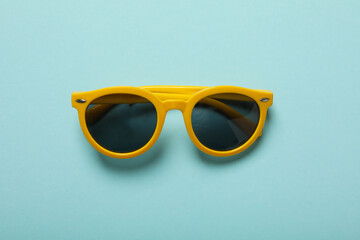 Sunglasses on a blue background, top view