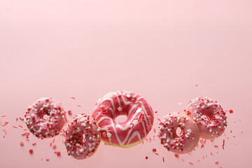 Pink donuts levitate in the air on a pink background