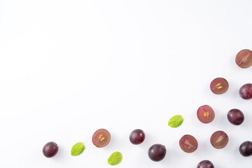 Delicious bunch of grapes fruit spilled over white table background.
