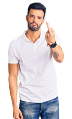 Young handsome hispanic man wearing casual clothes showing middle finger, impolite and rude fuck off expression