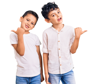 Couple of little brothers together wearing casual clothes smiling with happy face looking and pointing to the side with thumb up.