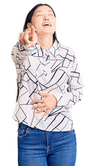 Young beautiful chinese woman wearing casual shirt laughing at you, pointing finger to the camera with hand over body, shame expression