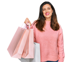 Beautiful hispanic woman holding shopping bags looking positive and happy standing and smiling with a confident smile showing teeth
