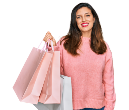 Beautiful hispanic woman holding shopping bags looking positive and happy standing and smiling with a confident smile showing teeth - Powered by Adobe