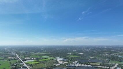 flying with blue sky day time view above little country side city with pollution and storm so far on horizon