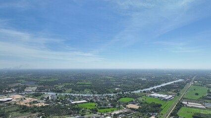 flying with blue sky day time view above little country side city with pollution and storm so far on horizon