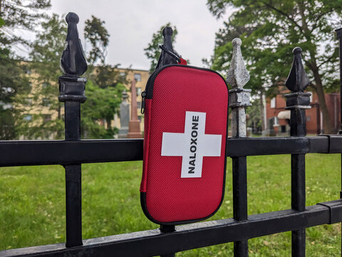 Free naloxone kit box hanging on the fence in city urban area park in Toronto Canada. Naloxone is a drug that can temporarily reverse an opioid overdose and can buy time until emergency arrives.