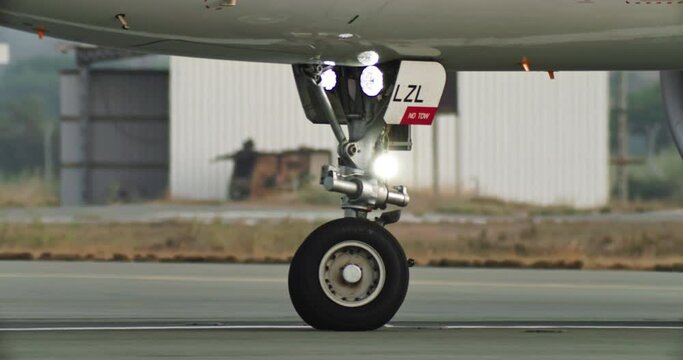 Slow-motion video close-up of the wheels of the plane traveling on the runway. High quality 4k footage