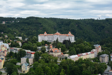 Fototapeta na wymiar Beautiful colorful buildings in traditional spa town of Karlovy Vary, Czech Republic. Traditional buildings of Karlovy Vary, bird's eye panorama with the hills in the background.