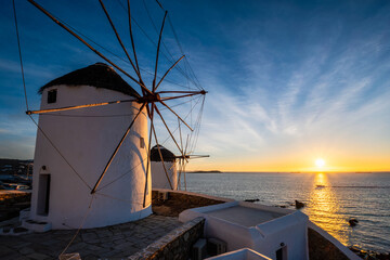 Scenic view of famous Mykonos town windmills. Traditional greek windmills on Mykonos island on sunset with dramatic sky, Cyclades, Greece. Walking with steadycam. - 623057303