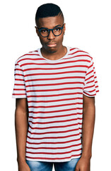 Young african american man wearing casual t shirt and glasses skeptic and nervous, frowning upset because of problem. negative person.