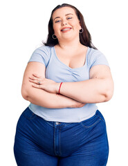 Young plus size woman wearing casual clothes happy face smiling with crossed arms looking at the...